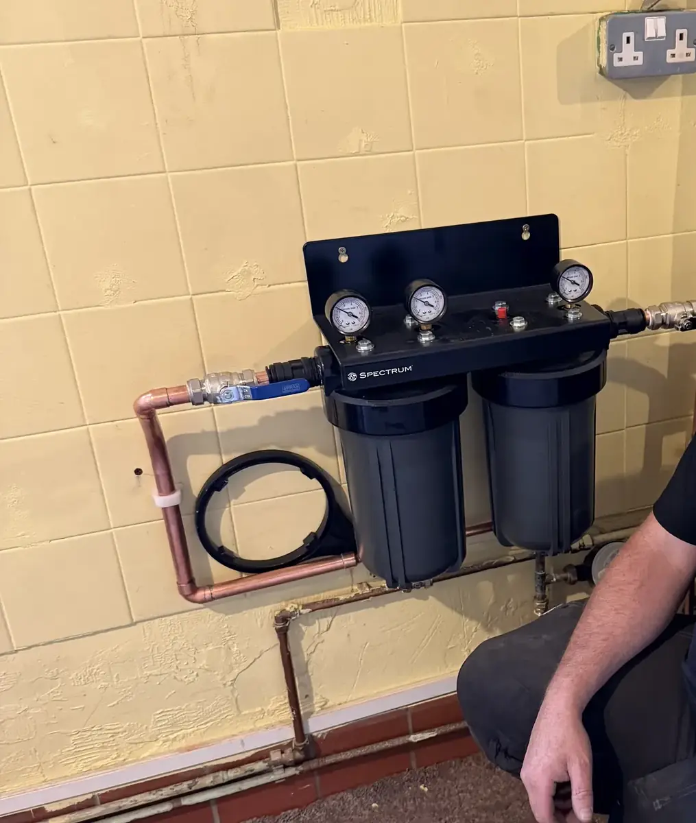 Twin-housing whole-house water filtration system fitted to a wall